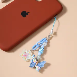 Detailansicht eines blauen Schmetterlings- und Blumen-Handy-Anhängers mit Perlen