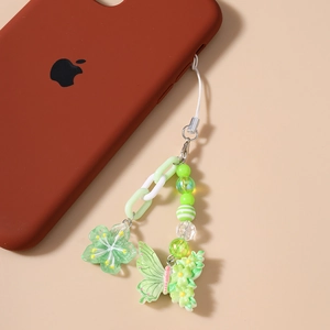 Detail der perlenbesetzten Handy-Handschlaufe mit grünen Blumen und Schmetterling