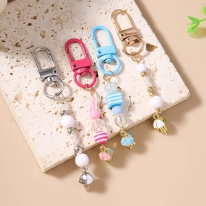 Colorful striped bead keychains with mini umbrella charms on stone background