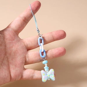 Detail of blue beaded star phone charm with chunky chain and dotted butterfly pendant