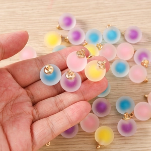 Detailed view of colorful frosted round geometric pendants with gold loops for DIY jewelry