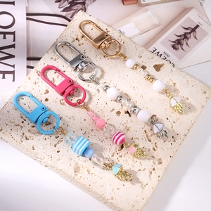 Close-up of colorful jellyfish keychains with striped beads and pearl tassels on stone