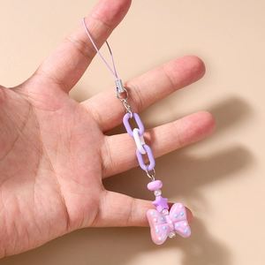 Detail of beaded mobile phone strap with purple star bead and polka dot bow pendant