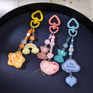 Detailed view of colorful beaded bear and rainbow charms on blue textured tray background
