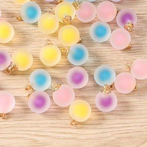 Flat lay of DIY frosted gradient round charms in assorted pastel colors with gold rings