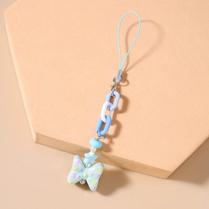 Macro detail of macaron beaded phone strap with blue chain links and green bow charm