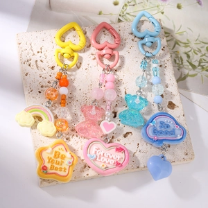 Detailed macro view of macaron colored bear and rainbow beaded keychains with heart hooks