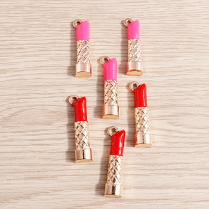 Close-up of pink and red lipstick charms with gold metal texture for DIY jewelry crafts