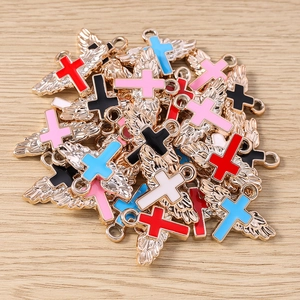 Macro view of gold angel wing cross charms in various enamel colors for DIY jewelry making
