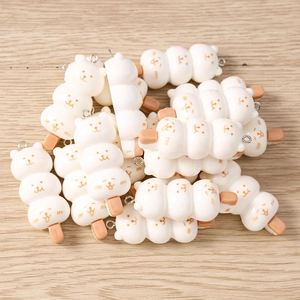Macro shot of cute cartoon bear food dango charms on wood for DIY jewelry making accessories