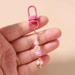 Detail of pink beaded keychain featuring striped beads and a ballet tutu charm
