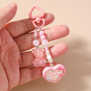 Detailed close-up of pink heart clasp with sequined bear and Forever Love pendant