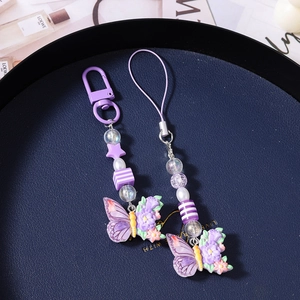 Close-up of purple acrylic butterfly and flower beaded charms with metal clasp and lanyard
