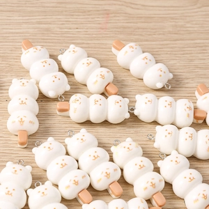 Macro shot of cute resin cat dango food charms with metal rings for DIY jewelry making