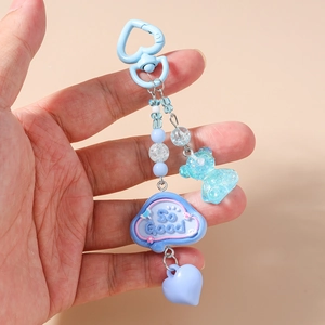 Detailed close-up of blue resin bear charm with cloud pendant and heart clasp keychain