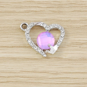 Macro shot of silver heart pendant with purple gemstone and crown detail for DIY crafts