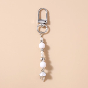 Detail of beaded keychain featuring a white jellyfish pendant and faux pearls for bags