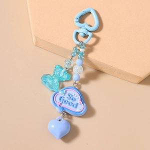 Close-up of blue beaded keychain featuring a glittery bear pendant and heart charm