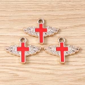 Detailed view of three red enamel angel wing cross pendants with silver alloy base