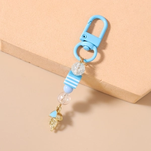 Detail showing blue striped beads and enamel jellyfish pendant on a beaded keychain