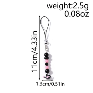 Détail de la dragonne en perles avec pendentif théière noire et motif de cœur rose gravé