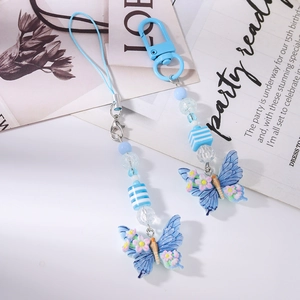 Close-up of blue butterfly phone charms and keychains set with beads and floral details