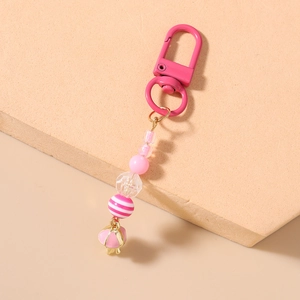 Detail view of pink beaded keychain with striped pearls and gold lobster clasp