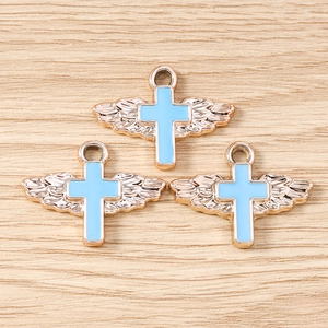 Close-up of golden angel wing cross charms with blue enamel for DIY jewelry making