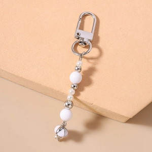 Close-up of beaded keychain with striped pearls and white umbrella charm accessory