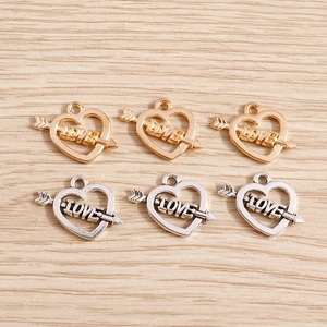 Detalle de dijes de corazón con flecha de Cupido en oro y plata con grabado LOVE
