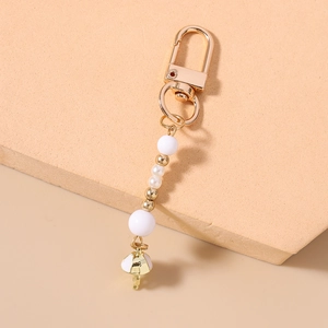 Detail of beaded keychain featuring white pearls and a stylish jellyfish tassel pendant