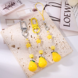 Macro shot of yellow pear charm set with star beads on textured stone surface