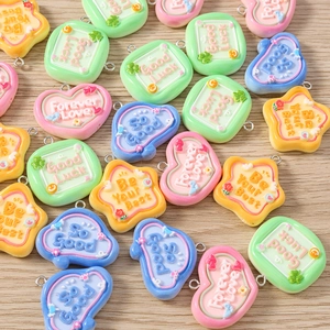 Close-up of heart and star resin charms with Forever Love text on wooden surface