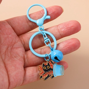 Detail of light blue keychain with cartoon black cat enamel charm and matching bell