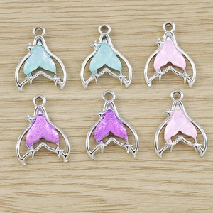 Detail of mermaid tail resin pendants in mint green, pink, and purple for jewelry making