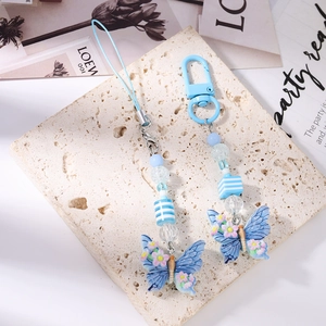 Close-up of sky blue butterfly beaded phone charm set with floral patterns on stone base