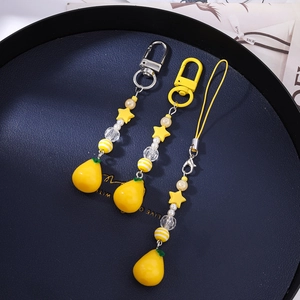 Detail of yellow pear charm beaded phone strap with star and pearl accents