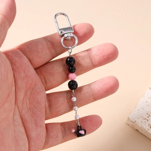Détail du porte-clés perlé avec breloque théière cœur rose et perles noires