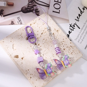 Detailed macro view of purple butterfly charms with assorted beads on a decorative background
