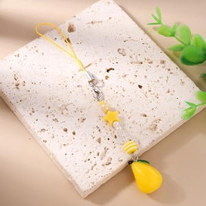 Detail of yellow lemon charm and star beads on a fresh-themed phone strap accessory