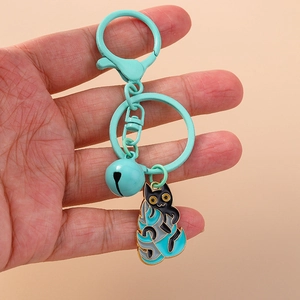 Detail of mint green metal keychain featuring a cute black cat pendant and a small bell