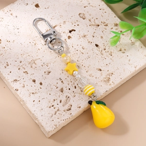 Detail of beaded keychain with yellow star, lemon pendant and silver carabiner clip