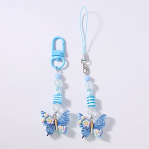 Detail of blue resin butterfly pendants with small pink flowers and decorative beads