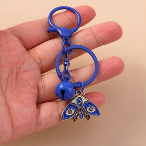 Detailed close-up of blue moth pendant keychain with bell and matte lobster clasp
