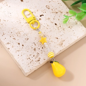 Detail of yellow beaded keychain with star bead and lemon pear charm on stone