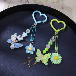 Porte-clés en perles avec papillon et marguerite sur un plateau bleu élégant