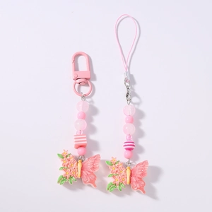 Close-up of pink beaded phone straps with resin butterfly pendants and flower details