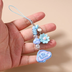 Detailed macro view of beaded phone strap with blue floral and So Good cloud charm