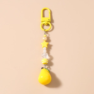 Detail of yellow pear charm with star beads on a keychain for bags and phone decoration