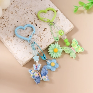 Porte-clés perles avec marguerite et papillon sur plateau en pierre naturelle